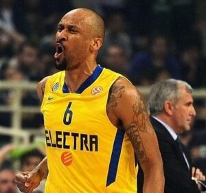 Devin Smith in action with a similar jersey during an Euroleague game. Zeljko Obradovic at the bottom