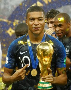 Mbappé wearing the jersey with the World Cup trophy